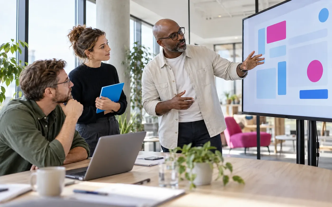 A product team discussing a software interface on a large screen